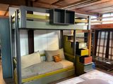 a bunk bed with a couch underneath it in a room