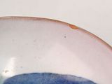 a bowl with a blue flower on it on a table