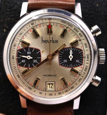a close up of a watch with a brown leather strap