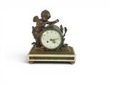 a small clock with a statue of a boy on it