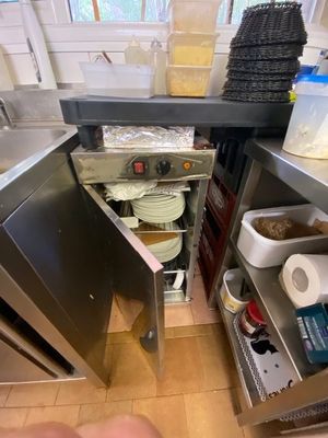 a person that is standing in a kitchen with a sink