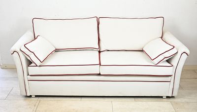 a white couch with red trim on it in a room