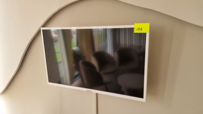 Téléviseur THOMSON avec fixation murale et sa télécommande. - Photo 1