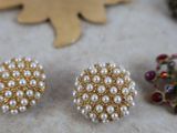 several different types of earrings and brooches are laid out on a table