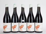 quatre bouteilles de vin sont alignées sur une surface blanche