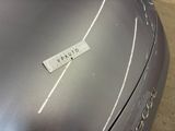 a close up of a silver car with a sticker on it