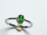 Gros plan sur une bague ornée d'une pierre verte