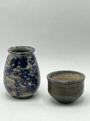 two vases sitting next to each other on a white surface