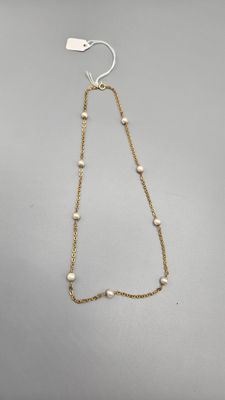 Chaine en or alternée de neuf perles de culture (en règle).