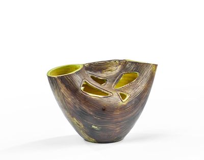 un vase marron et jaune posé sur une surface blanche