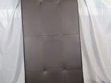 un fauteuil en cuir marron posé sur un drap blanc