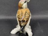 a figurine of a bird that is sitting on a branch