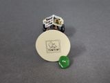 a small toy car and a small button on a table