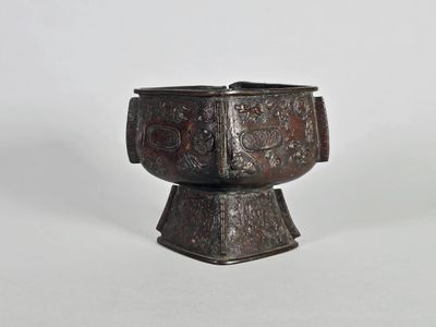 une vieille tasse en métal avec une anse, sur fond blanc
