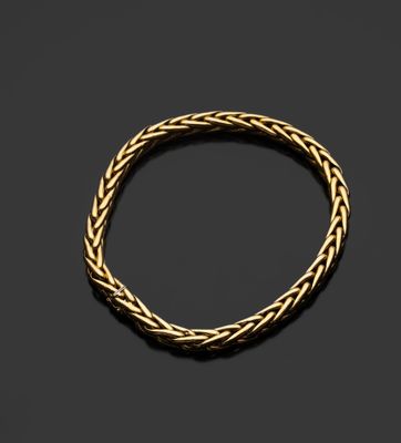 un bracelet en or avec un motif tressé sur fond noir
