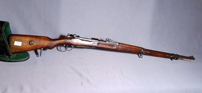 an old rifle is laying on a white surface next to a green hat