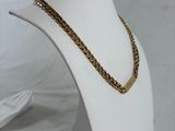 a close up of a mannequin with a gold chain on it