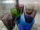 de nombreux verres de différentes couleurs exposés dans une vitrine