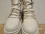 the box is full of white shoes with gold chains on them