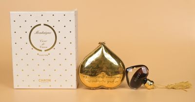 a close up of a perfume bottle and a box on a table