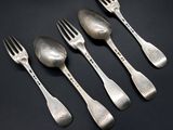 five silver spoons and a fork on a black surface