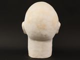 a close up of a sculpture of a head on a black surface