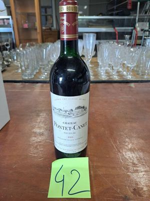 une bouteille de vin posée sur une table, avec des verres en arrière-plan