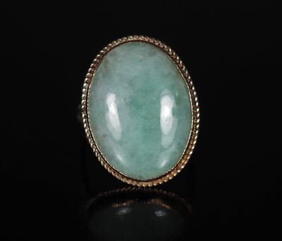 une bague en or sertie d'une pierre de jade verte au centre