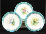 quatre assiettes bleues et blanches ornées de fleurs, sur un fond noir