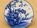 une assiette bleue et blanche ornée d'un oiseau et de fleurs