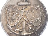 une vieille pièce d'argent sur laquelle figurent des armoiries et une croix