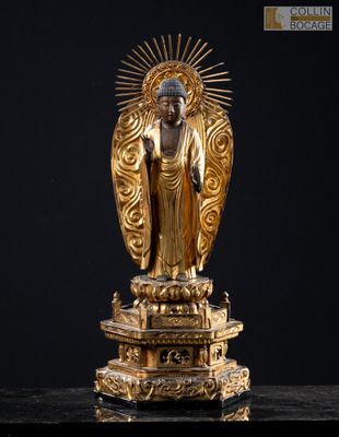 une statue en or représentant un Bouddha assis sur une table