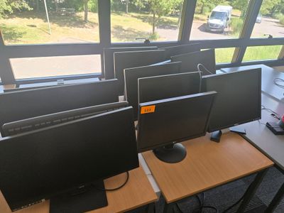 de nombreux écrans d'ordinateur posés sur les bureaux de la pièce
