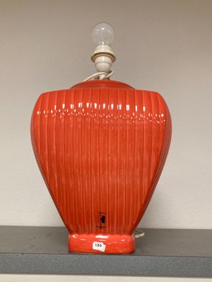 a red lamp that is on top of a shelf