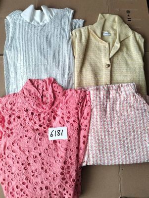 trois paires de pulls sont posées sur une boîte en carton sur laquelle est accrochée une étiquette de prix