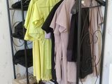 a rack with clothes on it in the corner of a room