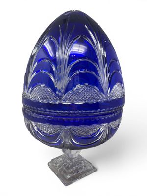 blue glass egg shaped box with a stand on a white surface