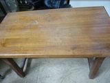 une petite table en bois avec une chaise noire en arrière-plan