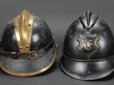 two helmets with gold trims are sitting side by side on a gray surface