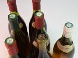 several bottles of wine are lined up on a white surface