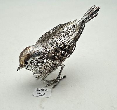 a silver bird that is sitting on a white surface