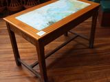 une petite table avec un plateau en verre posée sur un parquet