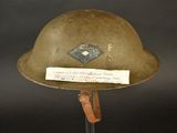 an old military helmet with a note on it on a stand