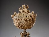 sculpture of a bowl with figures on it on a pedestal