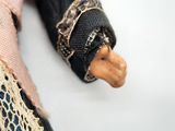 a close up of a doll with a pink tie