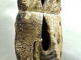 une sculpture représentant un oiseau dont le visage est percé d'un trou