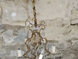 a chandelier hanging from a stone wall in a room