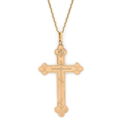 un pendentif en forme de croix en or, monté sur une chaîne en or