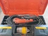 une boîte à outils orange contenant une perceuse et un câble