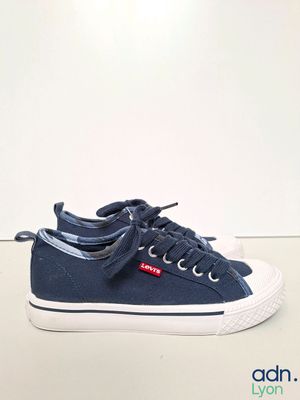 a close up of a pair of blue sneakers on a white surface